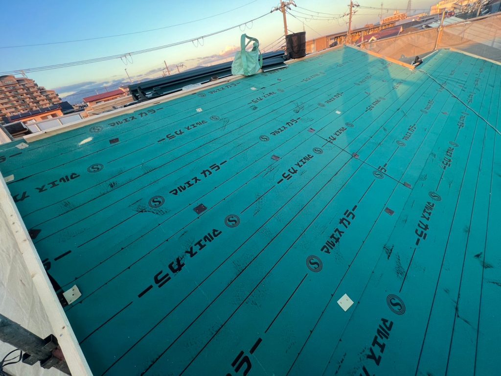 既存の屋根の上から防水シートを敷設していきます。